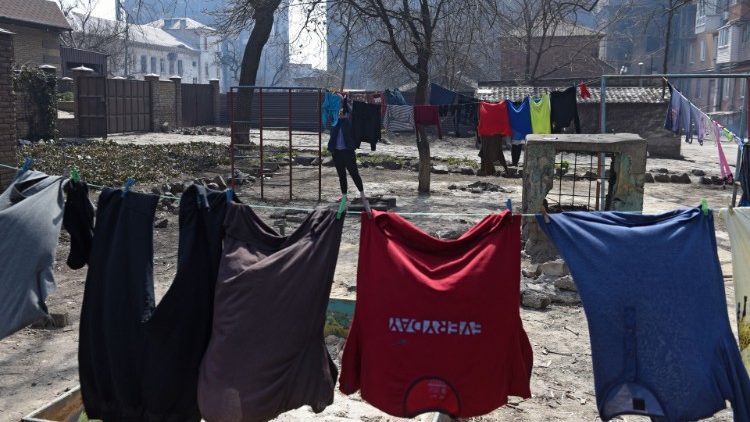 Uma mulher pendura sua roupa do lado de fora de um prédio de apartamentos durante o conflito Ucrânia-Rússia na cidade portuária de Mariupol, no sul da Ucrânia, em 3 de abril de 2022 REUTERS/Stringer
