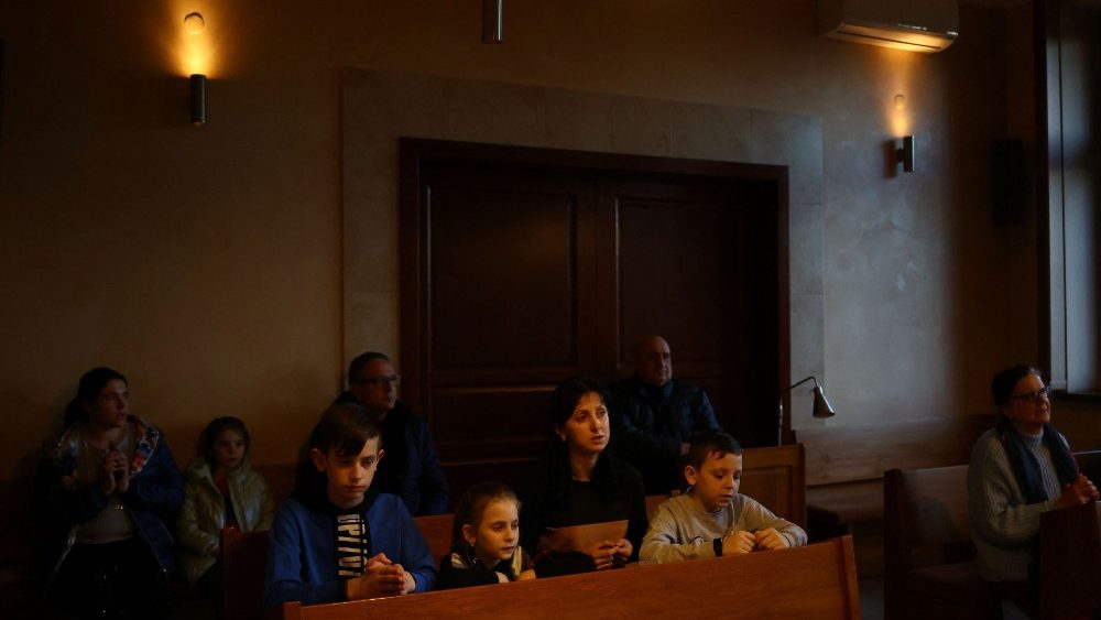 Refugiados ucranianos rezam durante uma Missa no Mosteiro das Irmãs Beneditinas que acolheu refugiados em meio à invasão da Ucrânia pela Rússia, em Jaroslaw, Polônia, em 22 de março de 2022. As seis freiras que administram o mosteiro fornecem refeições no refeitório e os moradores ajudaram com assistência financeira , roupas e brinquedos. REUTERS/Hannah McKay