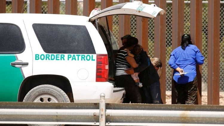 Migrantes en busca de asilo se abrazan cerca del muro fronterizo tras cruzar el río Bravo, en El Paso, Texas