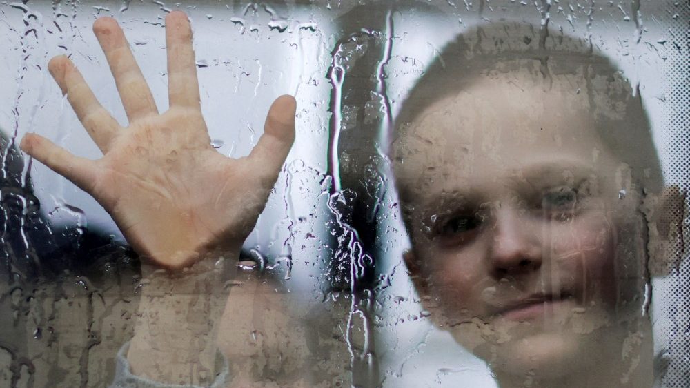 Menino ucraniano despede-se de seus pais, ao deixar abrigo organizado por voluntários na cidade ucraniana de Zaporizhzhya, em 14 de abril de 2022. (Reuter/Ueslei Marcelino)