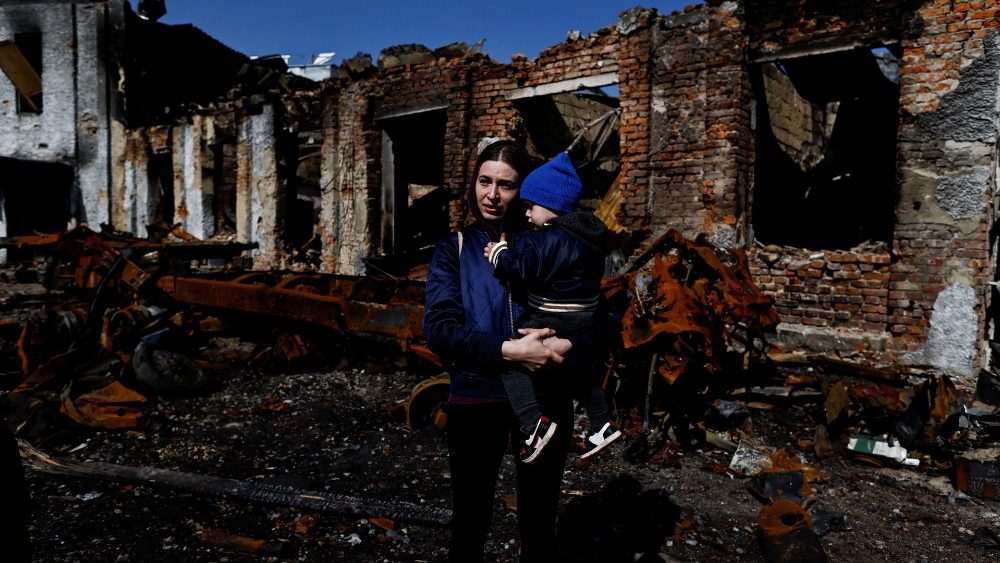 Inna, 28, e seu filho Sviatoslav, 2, ao lado de um veículo do exército russo destruído, em meio à invasão russa da Ucrânia, em Trostianets, região de Sumy, Ucrânia 15 de abril de 2022. REUTERS/Zohra Bensemra