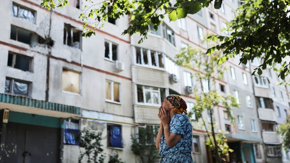 Uma mulher choocada em frente a um prédio danificado que foi atingido por um ataque militar, enquanto a invasão da Ucrânia pela Rússia continua, em Kharkiv, Ucrânia 15 de julho de 2022 REUTERS/Nacho Doce