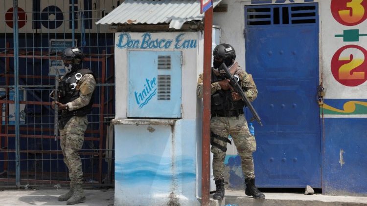 Members of the Haitian National Police patrol a street as gun battles between gangs continue. 