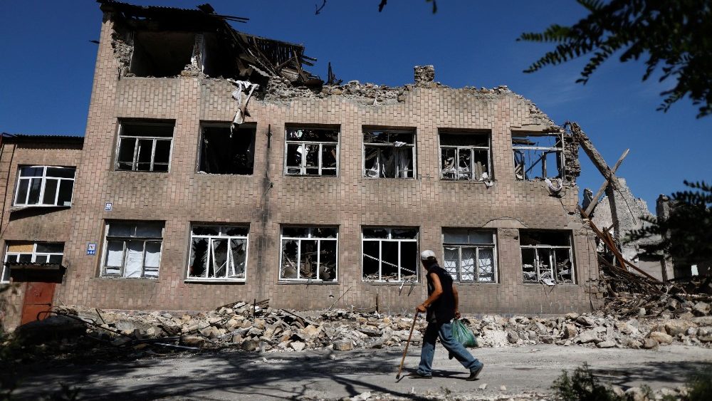 Homem caminha em frente à escola destruída por ataque russo em Toretsk, Donetsk, em 22 de agosto de 2022. (Photo by REUTERS/Ammar Awad)