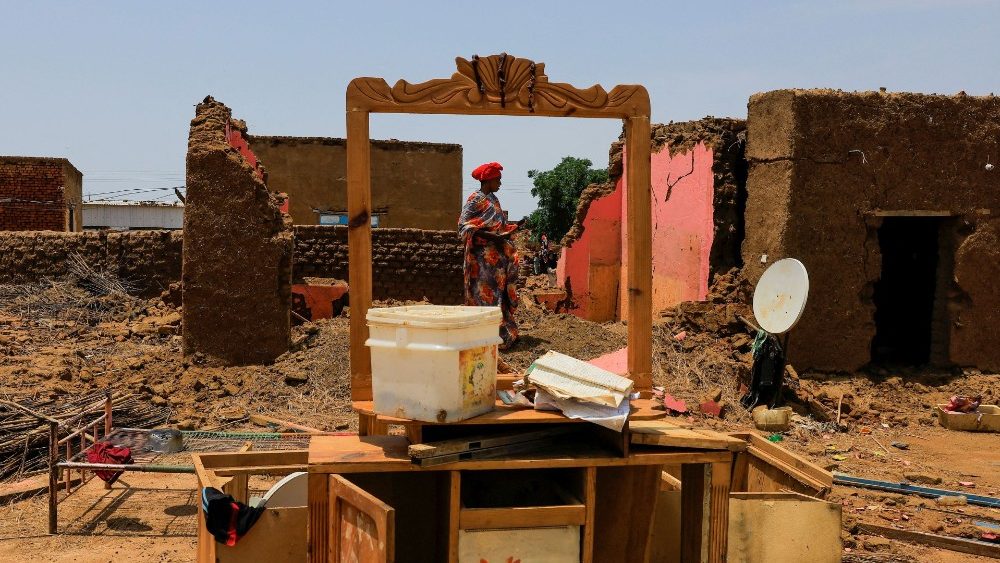 Mulher recolhe seus pertences após sofrer danos causados pela água em sua casa durante enchentes na localidade de Al-Managil, no estado de Jazeera, Sudão, 23 de agosto de 2022. REUTERS/Mohamed Nureldin Abdallah