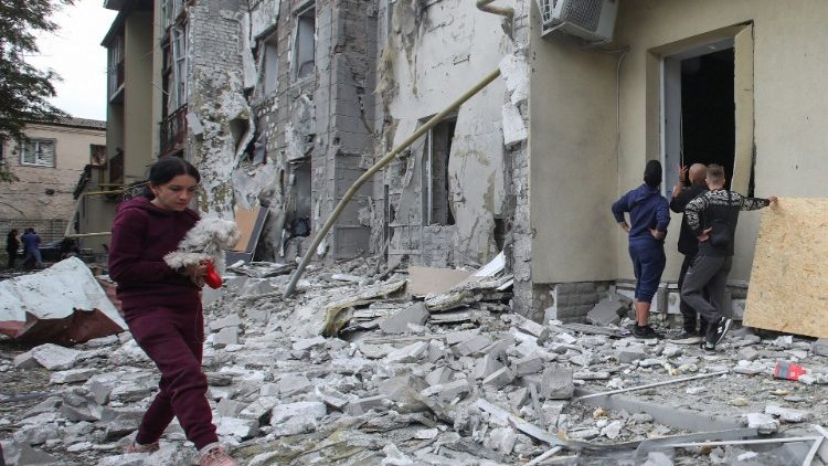 Uma mulher carrega um cachorro em frente a um prédio residencial danificado por um ataque de míssil russo, em meio ao ataque da Rússia à Ucrânia, em Kharkiv, Ucrânia 12 de setembro de 2022 REUTERS/Vyacheslav Madiyevskyy