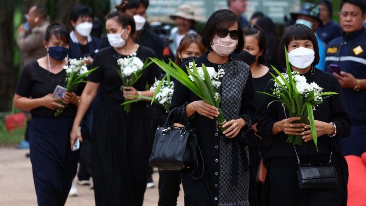 Mujeres llevan ofrendas florales ante la guardería escenario de la masacre en la ciudad de Uthai Sawan,