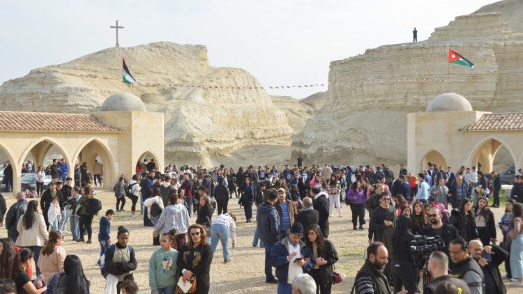 जॉर्डन घाटी में येसु का बपतिस्मा गिरजाघऱ के बाहर इकट्ठा हुए लोग