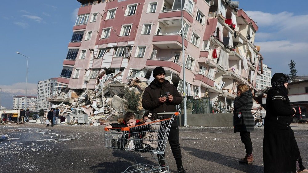 Crianças em um carrinho de compras perto de um prédio que desabou após um terremoto em Hatay, Turquia, 7 de fevereiro de 2023 REUTERS/Umit Be