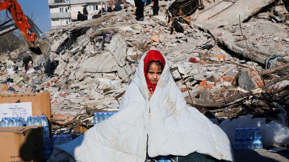 Uma menina senta perto do local de um prédio que desabou após um terremoto em Kahramanmaras, Turquia, 8 de fevereiro de 2023. REUTERS/Dilara Senkaya