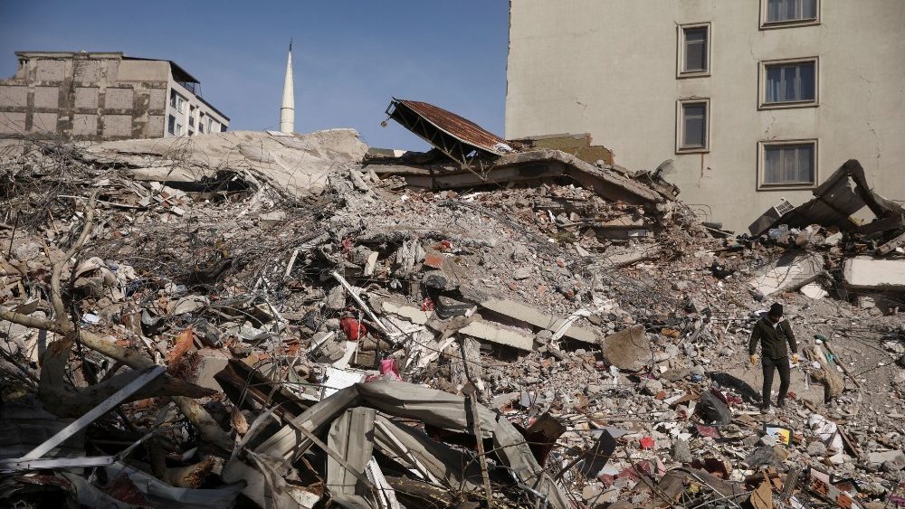 A man walks amid the rubble of a collapsed building, in the aftermath of a deadly earthquake in Kahramanmaras, Turkey February 8, 2023. REUTERS/Stoyan Nenov