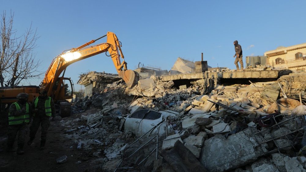 Pessoas passam por prédios danificados após um terremoto na cidade de Jandaris, controlada pelos rebeldes, na Síria, em 8 de fevereiro de 2023 REUTERS/Khalil Ashawi