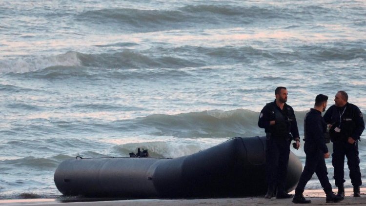 File image of policemen beside a dinghy used from crossing the English Channel
