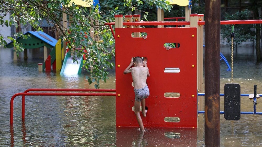 Um menino brinca em um playground em uma área inundada após o rompimento da barragem de Nova Kakhovka, em meio ao ataque da Rússia à Ucrânia, em Kherson, Ucrânia, 9 de junho de 2023. REUTERS/Ivan Antypenko TPX IMAGES OF THE DAY