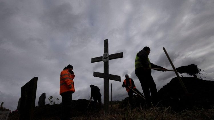 Digging graves for victims of a Russian missile attack in Hroza, near Kharkiv