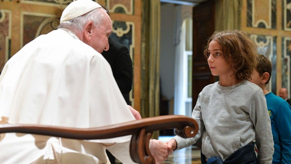 Papa saúda menina  acolhido pela "Comunidade Fronteira"