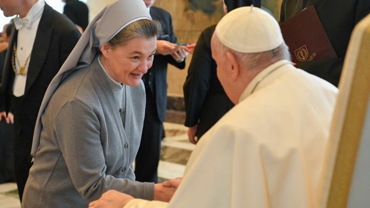Pope Francis greets a participant after his address