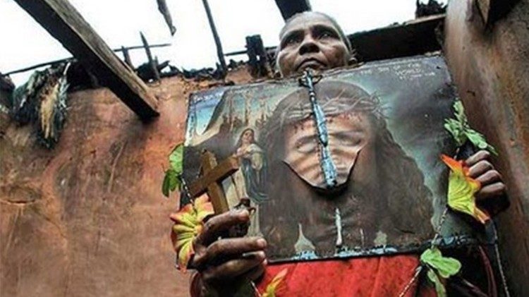 An Indian Christian woman standing amidst the ruins of her burnt home in Kandhamal, Odisha.