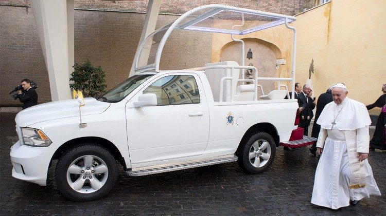 Pope Francis walking by donated Popemobile.