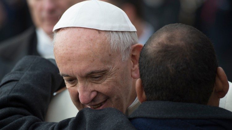 Pope Francis being hugged by a man