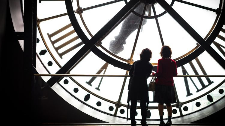 Frauen vor einer großen Uhr