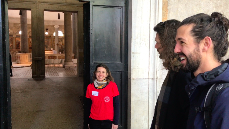 Valentina von Pietre Vive begrüßt zwei Kirchenbesucher. „Gäste sollen sich bei uns wie Zuhause fühlen", erklärt sie.