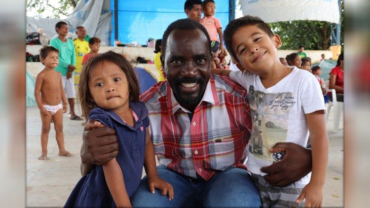 Un missionario originario del Kenya con due bambini venezuelani