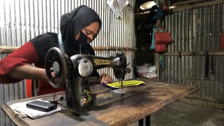 Una donna cuce una mascherina per il programma del Pam