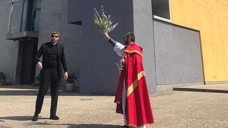 Il parroco e viceparroco di Santa Maria delle Grazie a Casal Boccone a Roma danno la benedizione,  nella domenica delle Palme, durante il lockdown per il coronavirus