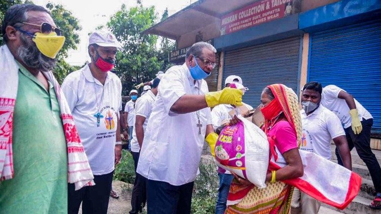 Archbishop Felix Toppo handing out food ration to a poor family. 