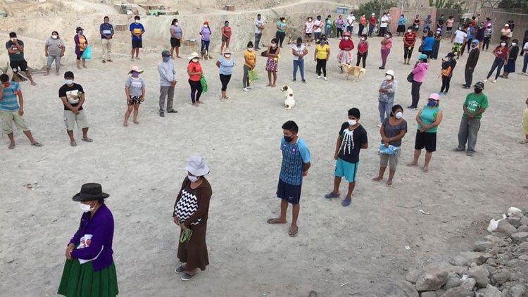 Filas respetando la distancia de seguridad para recibir la ayuda en tiempos de pandemia.