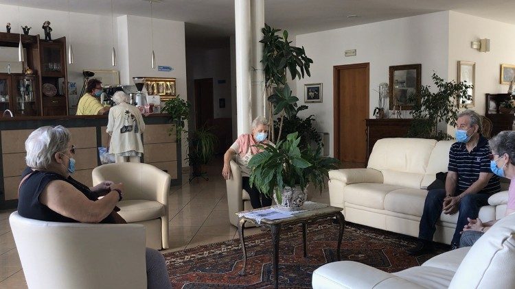 Anziani nell'atrio d'ingresso del Don Vecchi 2, con il bar e una zona ritrovo