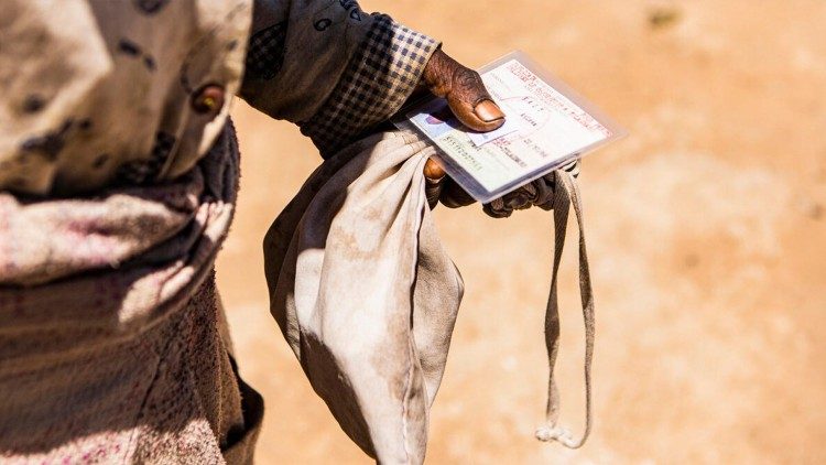 Stretta in mano la tessera che da' diritto alla razione di cibo