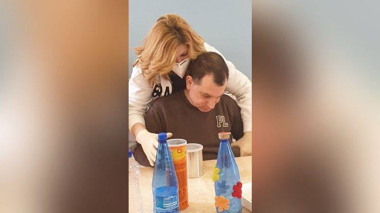 Una operatrice alle prese con il lavoro di cura ad un disabile ospite dell'Istituto Seraphicum