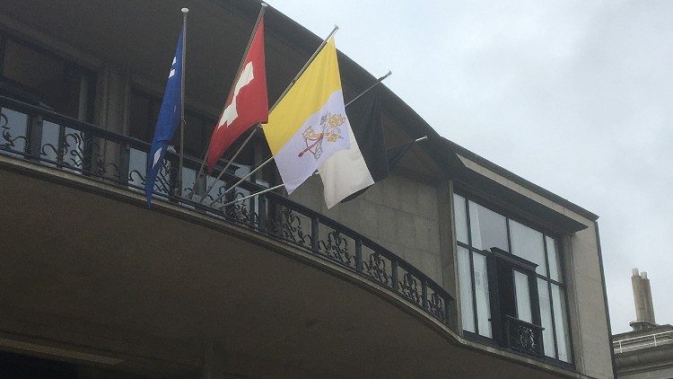 Eingang zur Aula Magna der Uni Fribourg mit den Fahnen der Schweiz und Vatikan