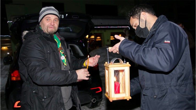 Il momento del passaggio della Luce di Betlemme dagli scout austriaci a quelli italiani al confine di Coccau (Tarvisio)