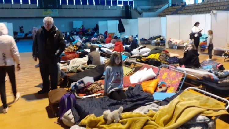 il cardinale Krajewski tra le brandine dove riposano le famiglie dei profughi alla stazione di Przemysl