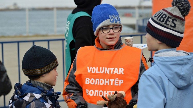 Giovanissimo volontario rumeno accoglie due bambini ucraini al confine. Foto Marco Giarracca (Jrs)
