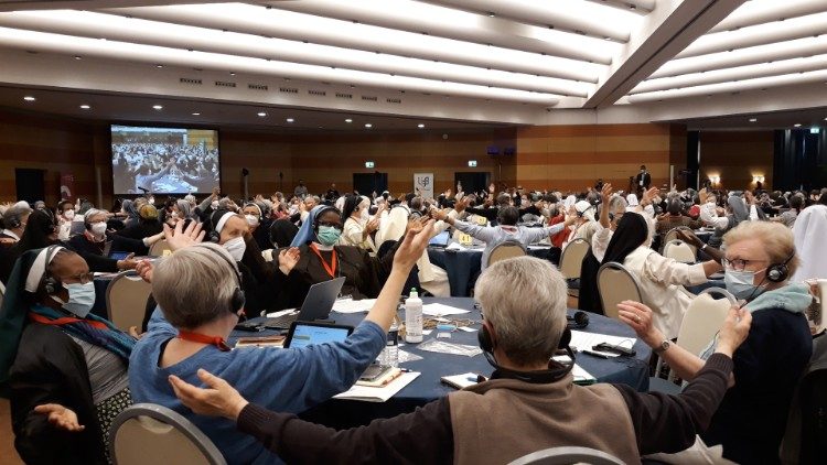 Sisters attending UISG Plenary, arms outstreched to embrace the world