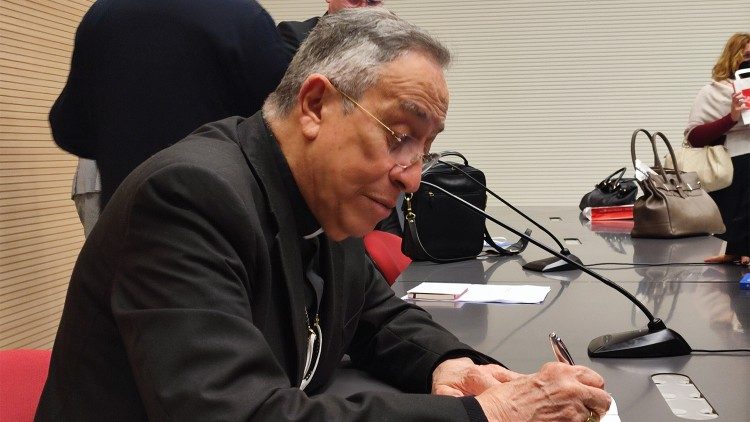 El cardenal Rodriguez Maradiaga firma el libro-entrevista al final de la presentación en el Palacio San Pio X