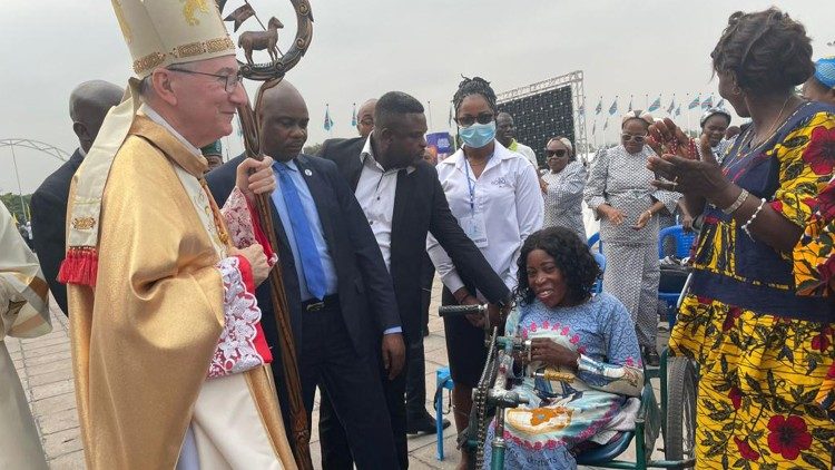 Cardinal Parolin greets a woman in a wheelchair