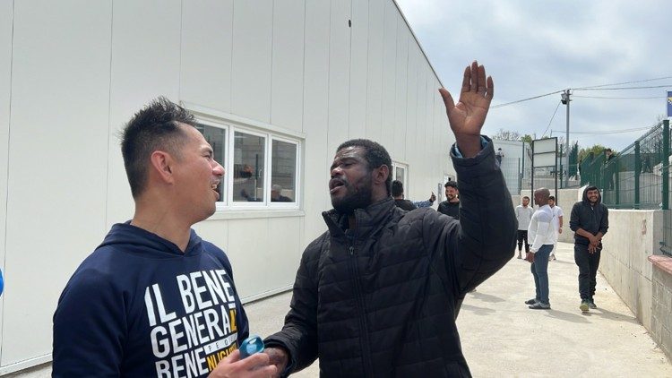 Un artista del Gen Rosso con un migrante