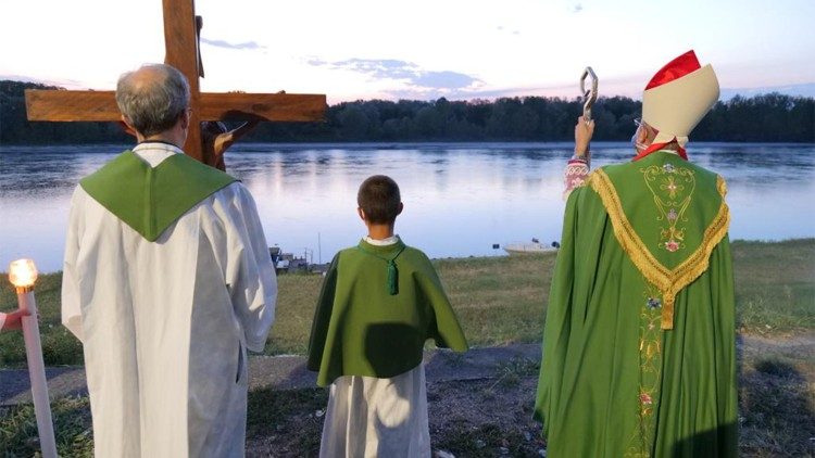 Monsignor Enrico Solmi mentre prega sulle rive del Po