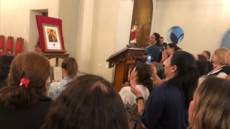 Os devotos em oração diante do ícone que seria entregue ao Papa