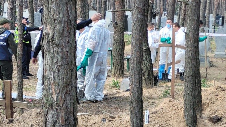 Voluntários ucranianos ajudando a retirar os corpos das valas comuns