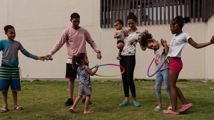 Enzor Figuera, a Venezuelan migrant, plays with his children while waiting to receive training and find stable work. (@Margherita Mirabella/Archivio GSF)