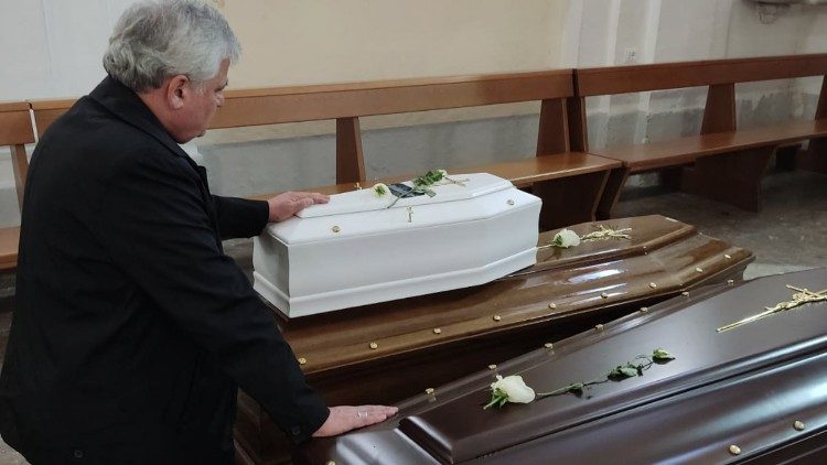 le cardinal Krajewski devant le cercueil d'un nouveau-né décédé à Ischia lors du glissement de terrain.