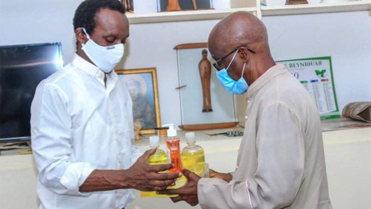 Le père Abekan offrant des cadeaux à l'évêque émérite du diocèse de Daloa, Mgr Maurice Konan, à travers l'initiative les Masques blancs. 