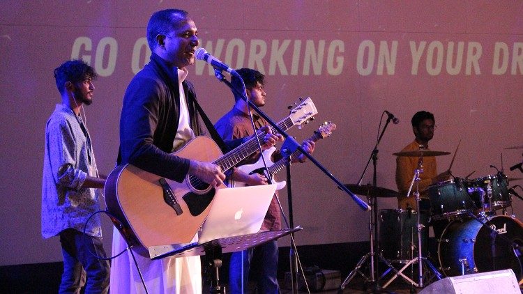Fr. Lijo Thomas performs with his band members