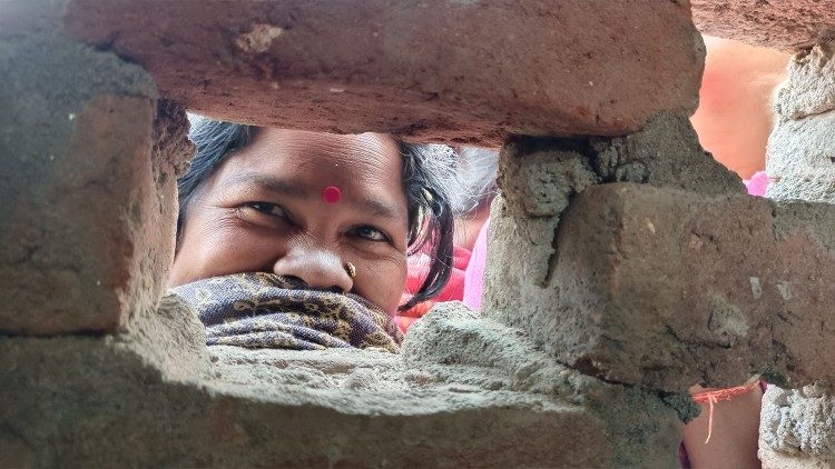 Musahar woman looking through a window